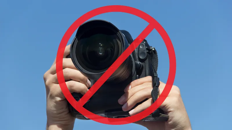 カメラを両手で構えているシーンに被せるように禁止マークがついている