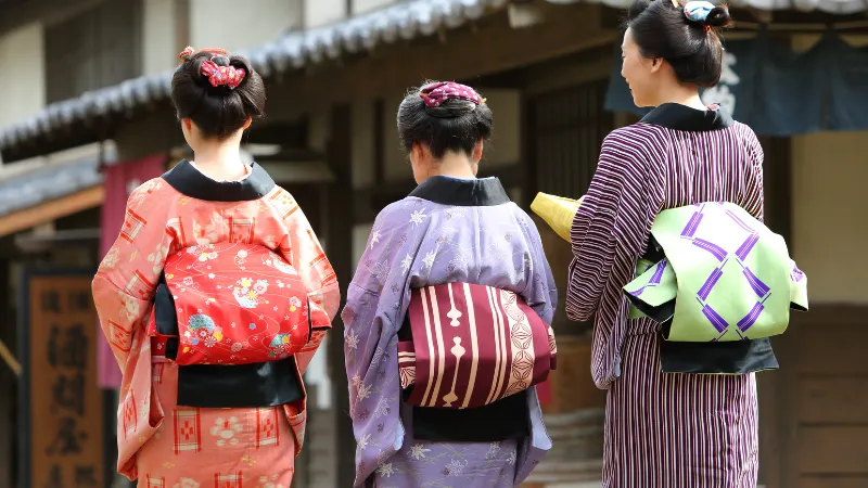 江戸時代の町を歩く着物姿の3人の女性の後ろ姿
