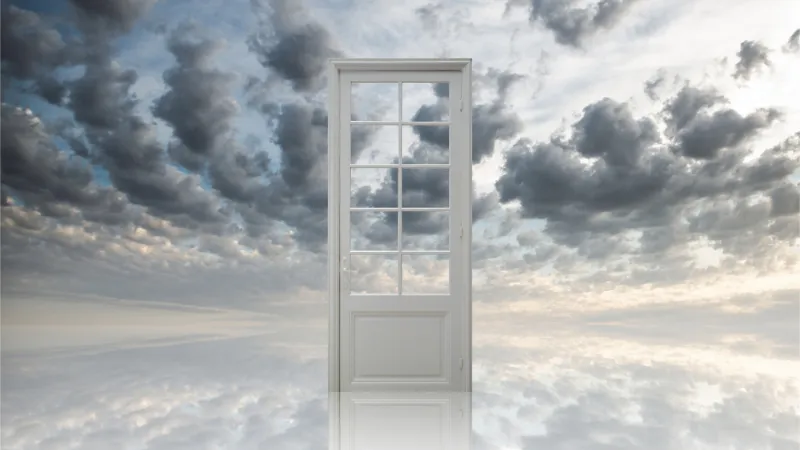 あの世との境界線のような、白と灰色の雲の中にある白い扉