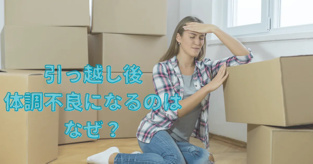 引越しの荷物にもたれかかりながら頭を押さえてつらそうな女性